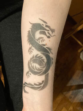 An arm with a black dragon airbrush tattoo, San Francisco